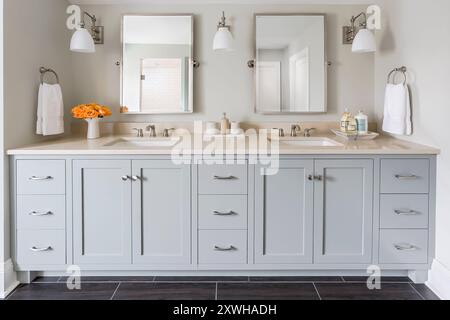 Beautiful double sink vanity in gray bathroom with swivel mirrors Stock Photo