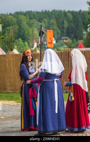 Women dressed in Medieval costumes are seen walking at the park. At the ...
