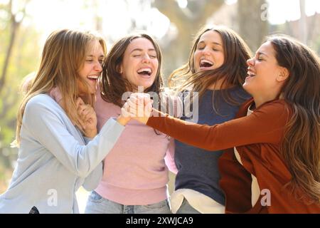 Four happy excited women celebrating success together in the street Stock Photo