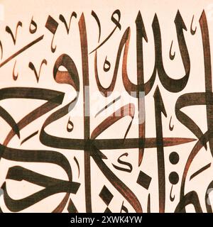 Islamic calligraphy characters on paper with a hand made calligraphy pen, Islamic art, in this article, the names of Allah (God) are written in arabic Stock Photo