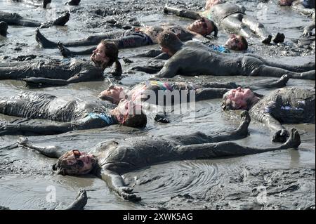 GERMANY, Schleswig-Holstein, Brunsbuettel, summer 2024, festival Wattolümpiade wadden olympics in wadden sea at german North Sea, many people have a wadden bath in the mud during low tide / DEUTSCHLAND, Brunsbüttel, Watt Olümpiade im Wattenmeer, Teilnehmer beim gemeinsamen Schlammbad im Schlick bei Ebbe Stock Photo