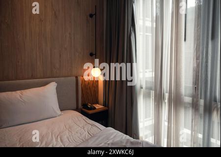 Interior cozy style of wooden bedroom with curtain and glowing lamp Stock Photo