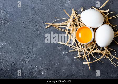 Raw white farm chicken eggs with egg yolk on rustic table Stock Photo