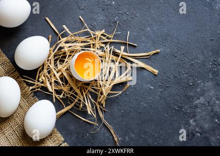 Raw white farm chicken eggs with egg yolk on rustic table Stock Photo