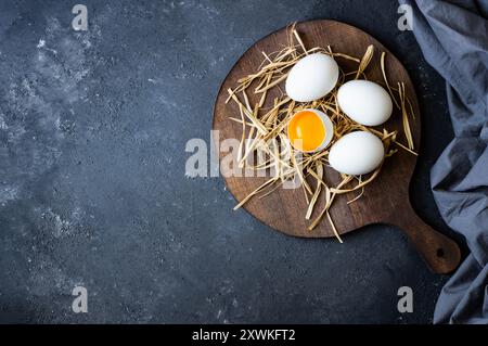 Raw white farm chicken eggs with egg yolk on rustic table Stock Photo