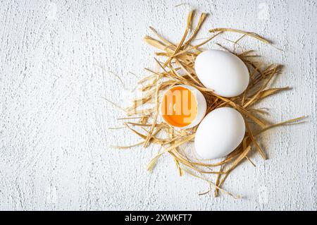 Raw white farm chicken eggs with egg yolk on rustic table Stock Photo