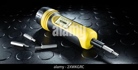 Different sized drivers next to a tool used to measure the number of inch pounds bolts are tightened down during repair or installation. Stock Photo