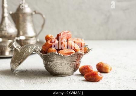 Ramadan palm fruit dates in silver bowl and zam zam water symbolize sacred month for muslims. Ramadan kareem food and drink fasting break concept Stock Photo