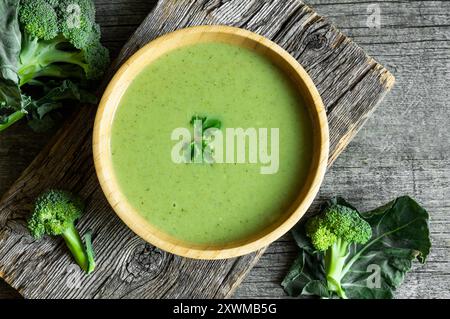 Fresh Broccoli soup in wooden bowl on dark table, diet detox food concept, top view Stock Photo
