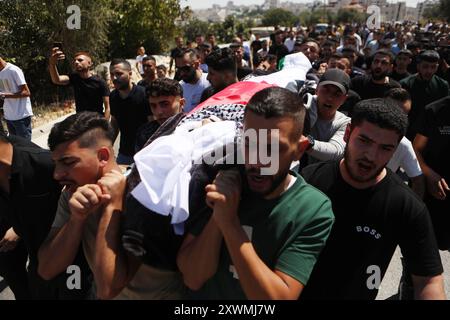 Mourners carry the body of an 18-year-old Palestinian who was killed in an Israeli raid, during his funeral in Dura near Hebron Mourners carry the body of an 18-year-old Palestinian who was killed in an Israeli raid, during his funeral in Dura near Hebron in the Israeli-occupied West Bank, August 20, 2024. Photo by Mamoun Wazwaz apaimages Hebron West Bank Palestinian Territory 200824 Hebron MW 0024 Copyright: xapaimagesxMamounxWazwazxxapaimagesx Stock Photo