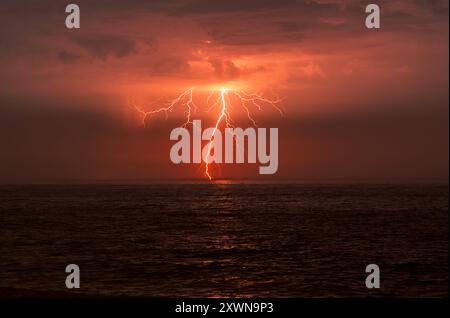 A dramatic cloud to ground lightning bolt over the sea in Norfolk, UK Stock Photo