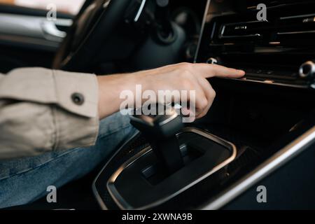 Closeup hands of unrecognizable driver male choosing favorite radio. Man pressing button on vehicle audio in car. Close-up of guy finger pressing Stock Photo