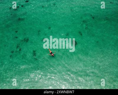 Tourist pleasantly swimming in the emerald waters of Phi Phi islands Stock Photo