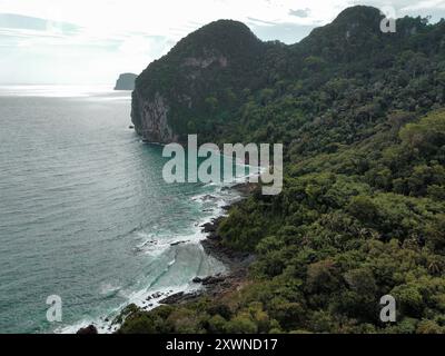 Aerial view of the tropical forest and limestone mountains from the Charlie Beach on Koh Mook on a cloudy day during the rainy season Stock Photo
