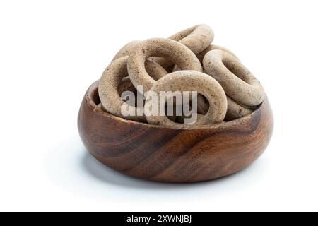 Small  whole grain bagels in wooden bowl isolated on white Stock Photo