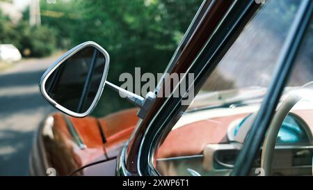 Vintage car side mirror and window detail. Classic automobile exterior close-up. Retro vehicle design elements and reflections. Stock Photo