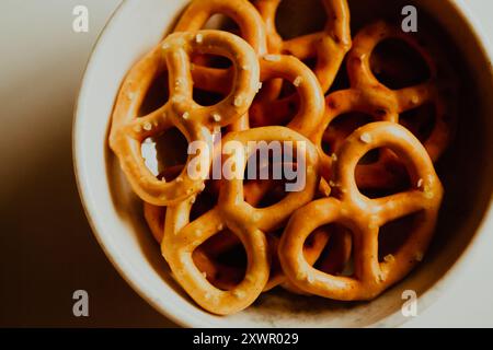Salted mini pretzels are arranged in a white dish. Homemade, delicious pastries. Baked goods. Stock Photo