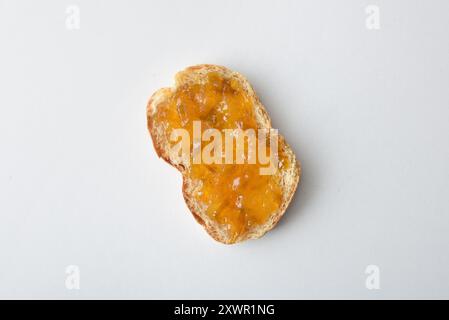 Toast with plum jam decorated with fruits isolated on white table. Top view. Stock Photo