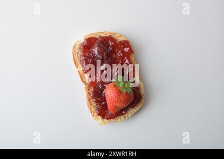 Toast with strawberry jam decorated with fruits isolated on white table. Top view. Stock Photo