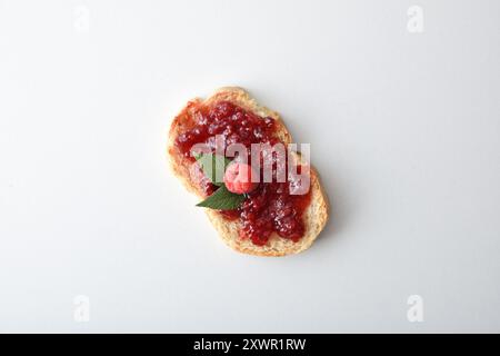 Toast with raspberry jam decorated with fruits isolated on white table. Top view. Stock Photo