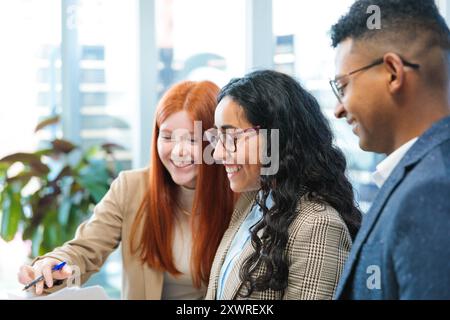 Close-up of young Latin businesspeople team focused collaborating on a project in a bright meeting room office Stock Photo