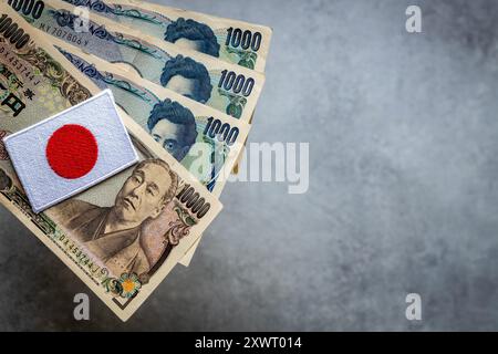 Japan money. Japan flag and banknotes of 1000 and 10000 thousand Japanese yen. Financial concept, close up, copy space, beautiful gray background Stock Photo