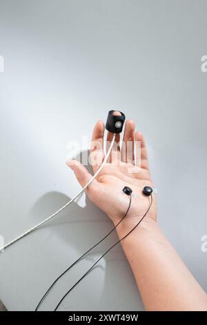 Close-up of a hand with medical sensors attached, used for monitoring health parameters or during diagnostic tests. Represents medical testing, health monitoring, and the importance of technological advancements in healthcare. Stock Photo