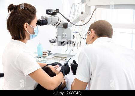 Two dentists making treatment in modern dental clinic Stock Photo