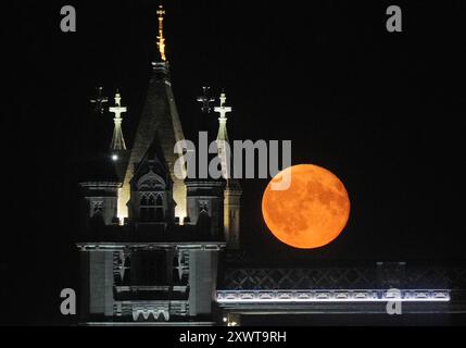 A waning gibbous moon rises over Tower Bridge in London. Picture date: Tuesday August 20, 2024. Stock Photo