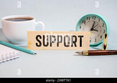 Support word written on wood block. Support text on cement table for your desing, concept. Stock Photo