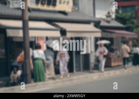 A blurred image of people walking along a street in Japan.  The background is blurred with bokeh effects. Stock Photo