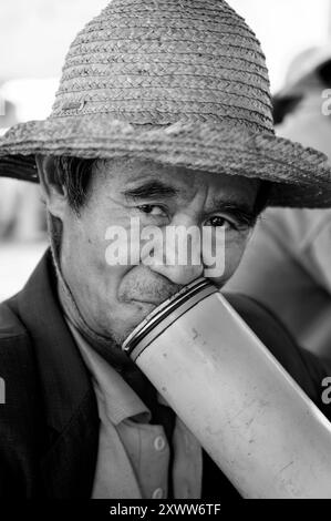 Afternoon smoke with a traditional Bamboo pipe. Photo taken in a weekly market in south Yunnan province, China. Stock Photo