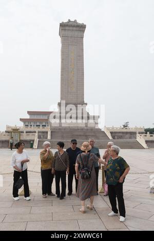 Beijing, China - August 17, 2024: Several elderly people take photos in front of the Monument to the People's Heroes Stock Photo