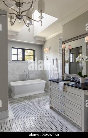 High end bathroom with stand alone bathtub and marble tile and dormer window Stock Photo