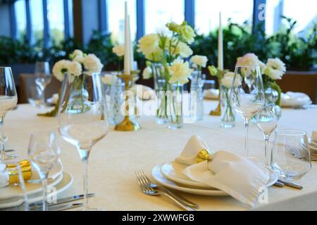 Table setting in a restaurant. Empty glasses set in restaurant. Table setting with glasses, cutlery and plates. Restaurant interior. Stock Photo