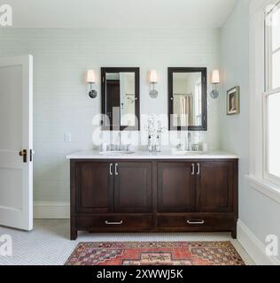 Double vanity with dark wood in bathroom with soft green wall tile Stock Photo