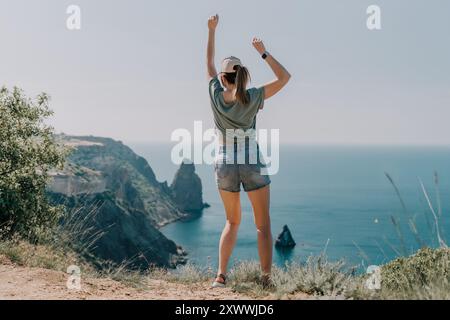 Woman Celebrating on a Clifftop with Ocean View Stock Photo