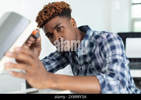 man repairs an electrical appliance using a screwdriver Stock Photo