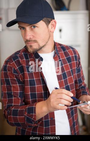 young happy handsome bearded male industry worker writing notes Stock Photo