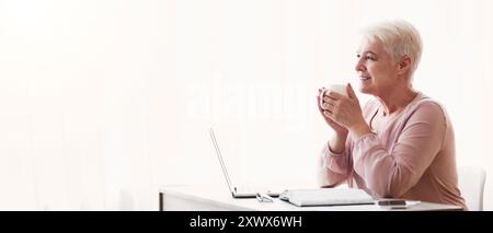 Peaceful old lady having coffee break during working day Stock Photo