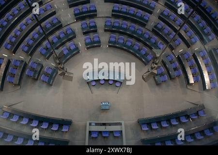 This image captures an aerial view of the plenary chamber at the Bundestag in Berlin. The modern architecture, circular seating arrangement, and design elements are evident, highlighting the significance of the location in German politics. Stock Photo