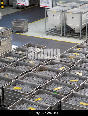 A detailed view of organized metal components in storage bins at the Fischerwerke GmbH factory in Waldachtal, showcasing efficiency in industrial production and inventory management in a modern manufacturing facility. Stock Photo