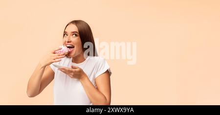 Pregnant Woman Eating Donut Standing On White Background, Panorama Stock Photo