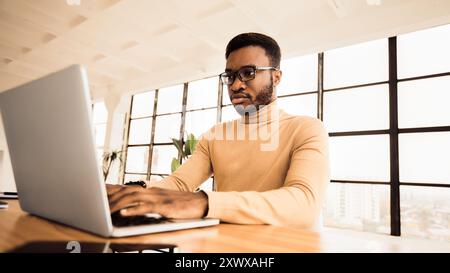 Concentrated african american man working with laptop Stock Photo