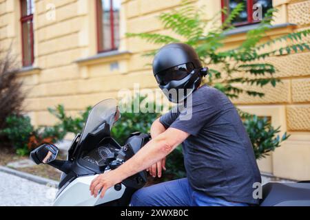 Biker in a helmet and leather protective equipment sits on a motorcycle, a sporty fast motorcycle Stock Photo