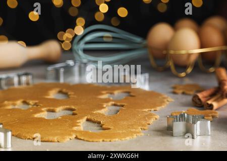Raw dough, cookie cutters and cinnamon sticks on grey table, closeup Stock Photo
