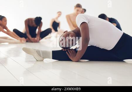Girl, ballerina and split for stretching in studio with training, muscle and start lesson at dance school. Person, dancer and warm up in class, floor Stock Photo