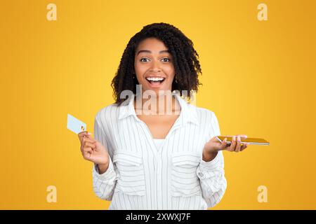 Surprised mixed race woman making purchases using phone Stock Photo