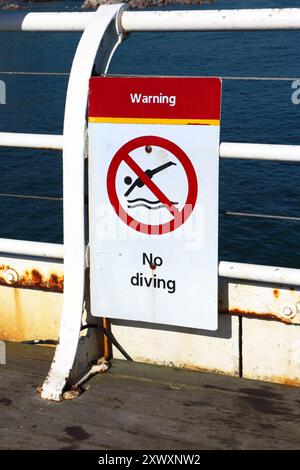 A Warning No Diving sign on the Pier on the North Norfolk coast at Cromer, Norfolk, England, United Kingdom. Stock Photo