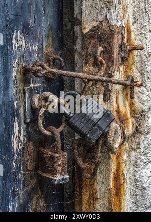 Two rusty padlocks on an ancient shed door Stock Photo